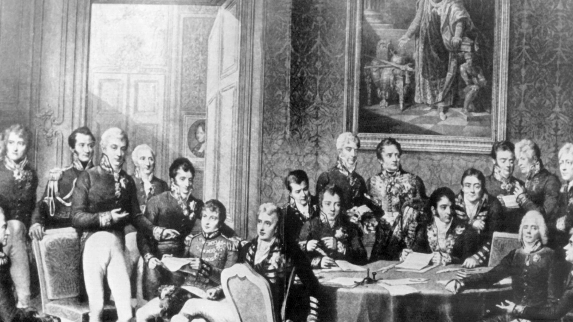 Der österreichische Staatsmann versuchte durch Kongreßdiplomatie, die vorrevolutionäre politische und soziale Ordnung in Europa wiederherzustellen. Er bekämpfte alle liberalen und revolutionären Bewegungen. Klemens Wenzel Fürst von Metternich wurde am 15. Mai 1773 in Koblenz geboren und ist am 11. Juni 1859 in Wien gestorben. Die zeitgenössische Darstellung zeigt stehend (l-r): Wellington, Lobo da Silveira, Saldanha da Gama, Löwenhjelm, Noailles, Metternich, La Tour du Pin, Nesselrode, Dalberg, Rasumofsky, Stewart, Clancarty, Wacken, Gentz, Humbold, Cathcart sowie sitzend (l-r): Hardenberg, Palmella, Castlereagh, Wessenberg, Labrador, Talleyrand und Stackelberg. Der österreichische Staatsmann versuchte durch Kongreßdiplomatie, die vorrevolutionäre politische und soziale Ordnung in Europa wiederherzustellen. Er bekämpfte alle liberalen und revolutionären Bewegungen. Klemens Wenzel Fürst von Metternich wurde am 15. Mai 1773 in Koblenz geboren und ist am 11. Juni 1859 in Wien gestorben. Die zeitgenössische Darstellung zeigt stehend (l-r): Wellington, Lobo da Silveira, Saldanha da Gama, Löwenhjelm, Noailles, Metternich, La Tour du Pin, Nesselrode, Dalberg, Rasumofsky, Stewart, Clancarty, Wacken, Gentz, Humbold, Cathcart sowie sitzend (l-r): Hardenberg, Palmella, Castlereagh, Wessenberg, Labrador, Talleyrand und Stackelberg.
