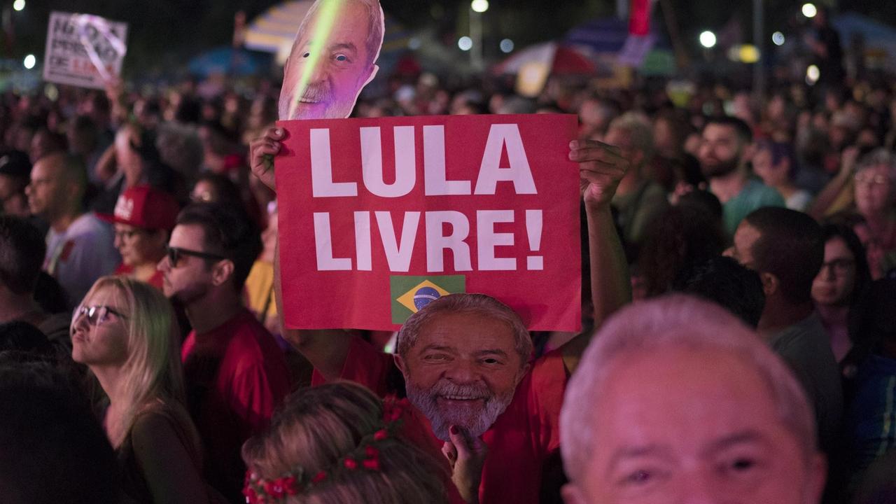Besucher des "Lasst Lula frei"-Konzerts in Rio. Ein Unterstützer des inhaftierten Expräsidenten hält ein Schild mit dem Schriftzug"Lula Livre" hoch.