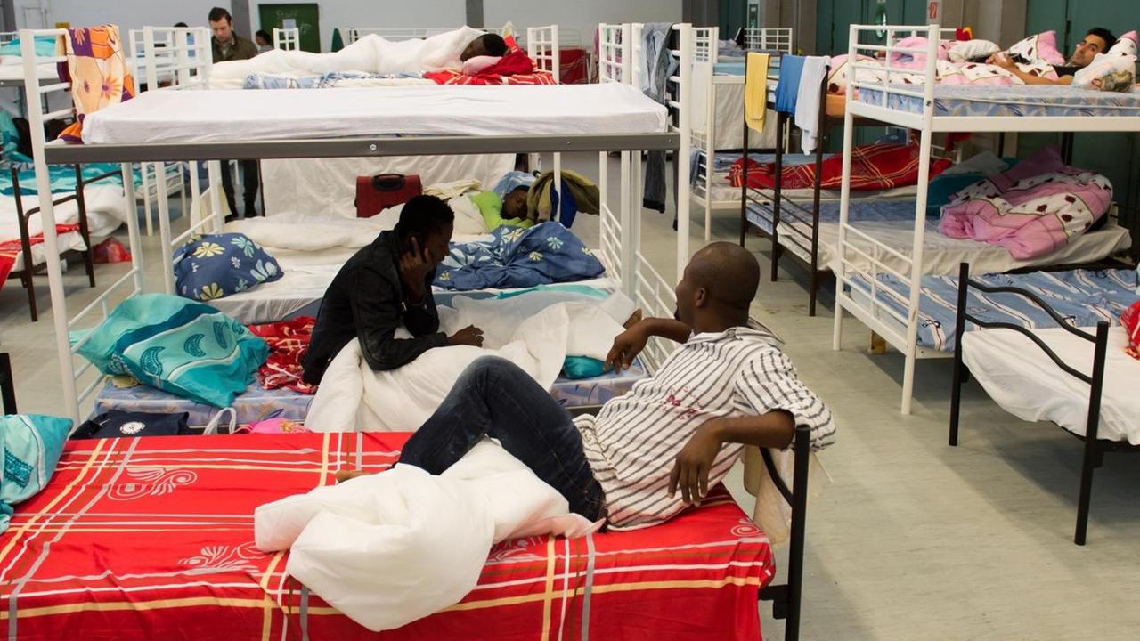 Flüchtlinge aus verschiedenen Ländern im Erstaufnahmelager in der Lkw-Garage der Bayernkaserne in München. Flüchtlinge aus verschiedenen Ländern im Erstaufnahmelager in der Lkw-Garage der Bayernkaserne in München.