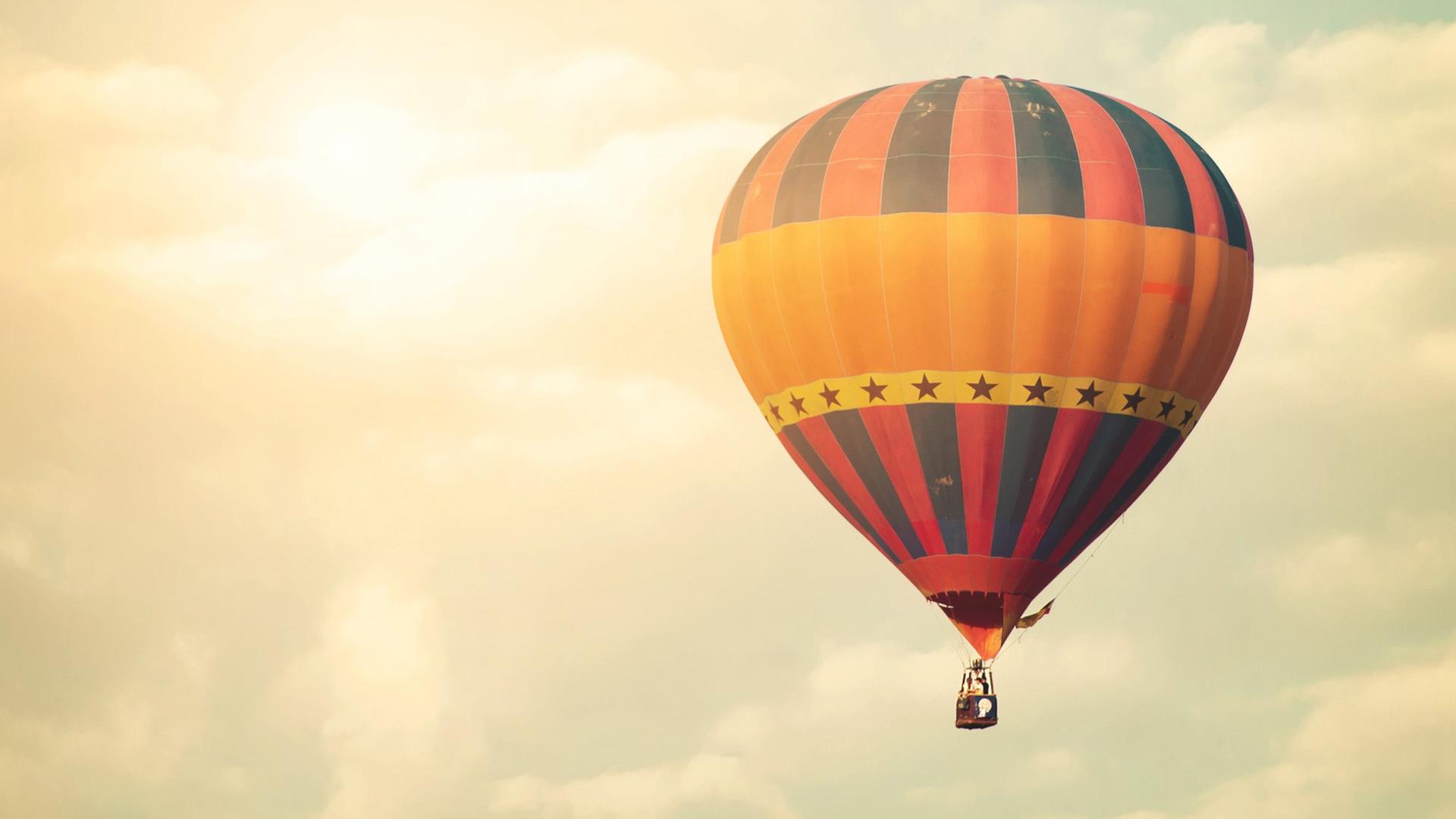 Ein Heißluftballon vor einem Himmel mit Wolken Ein Heißluftballon vor einem Himmel mit Wolken