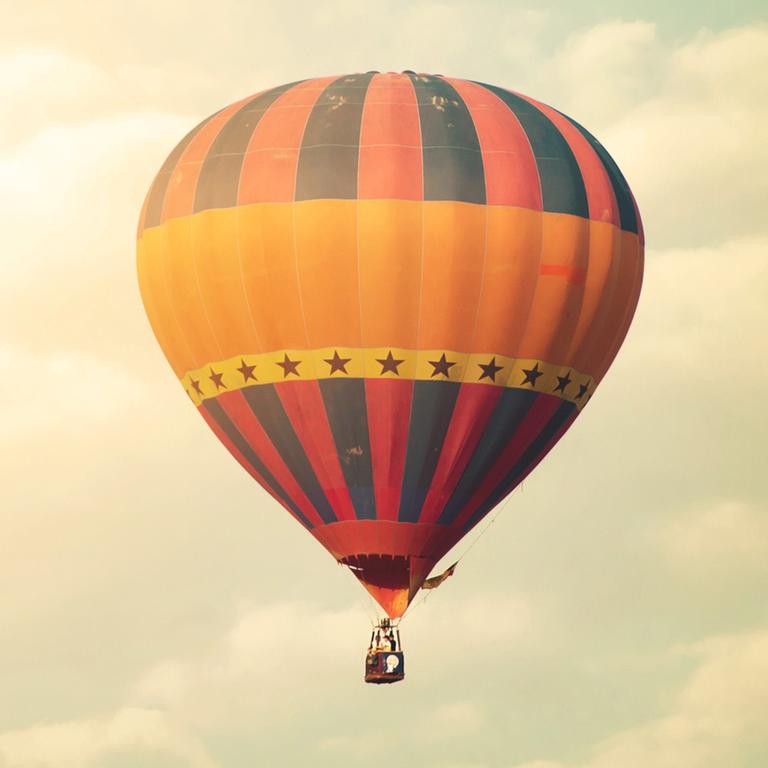 Ein Heißluftballon vor einem Himmel mit Wolken Ein Heißluftballon vor einem Himmel mit Wolken