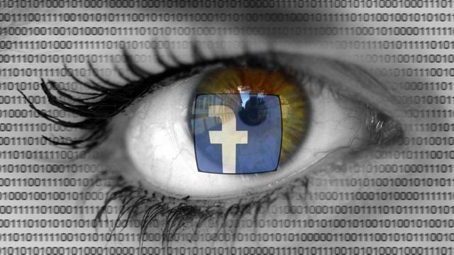 Der Schiftzug "Facebook" spiegelt sich in den Augen einer besorgt blickenden Frau