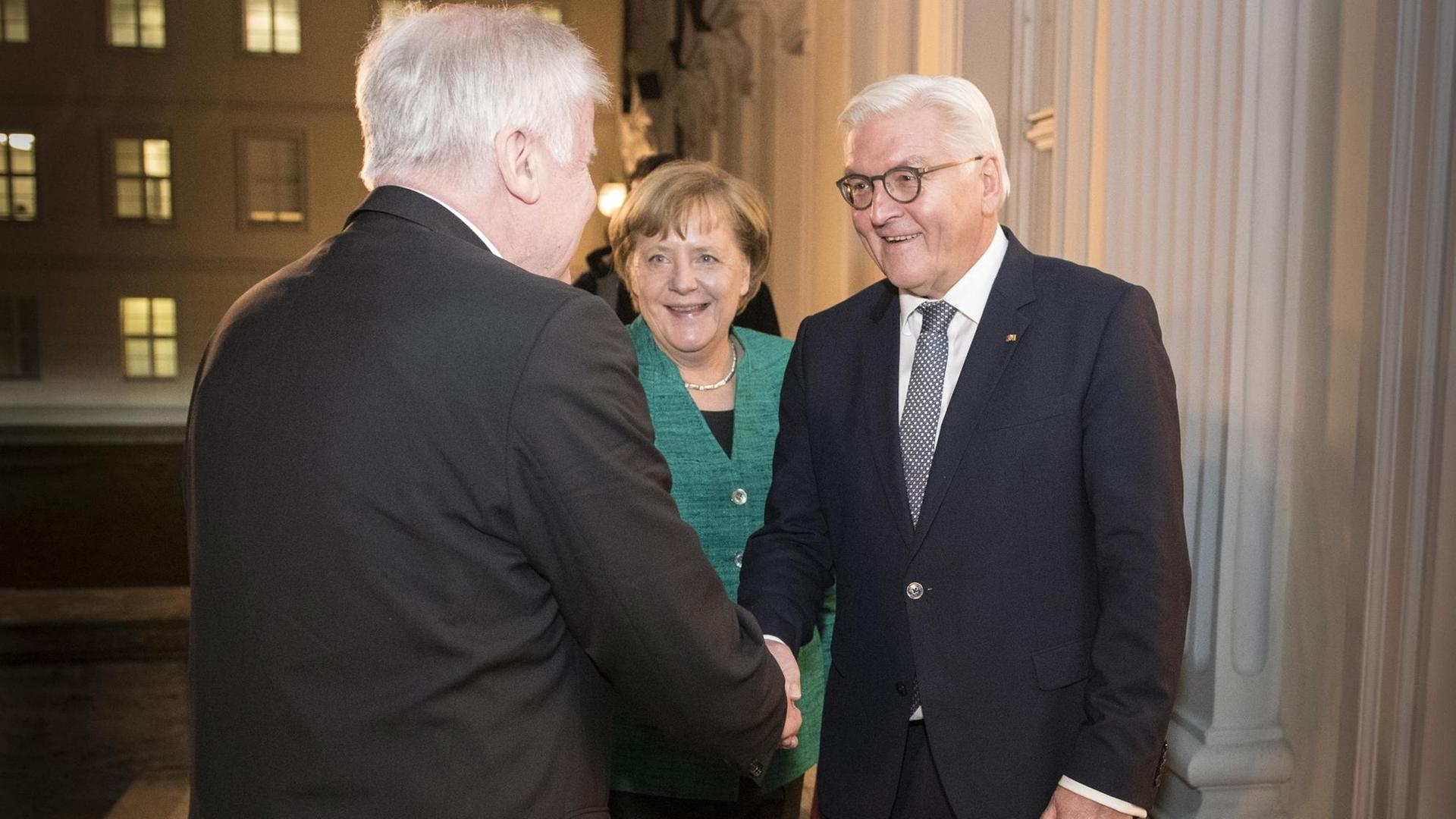 HANDOUT - Bundespräsident Frank-Walter Steinmeier (r) begrüßt am 30.11.2017 den CSU-Vorsitzenden Horst Seehofer (l) und die CDU-Vorsitzende Bundeskanzlerin Angela Merkel zu einem Gespräch in Schloss Bellevue in Berlin. Steinmeier beendete mit diesem Treffen eine Serie von Gesprächen, die er unmittelbar nach dem Scheitern der Sondierungen für eine Jamaika-Koalition aus Union, FDP und Grünen begonnen hatte, um Neuwahlen zu vermeiden. (ACHTUNG: Verwendung nur zu redaktionellen Zwecken im Rahmen der aktuellen Berichterstattung bei vollständiger Quellenangabe "Guido Bergmann/Bundesregierung/dpa" - Kein Verkauf) Foto: Guido Bergmann/Bundesregierung/dpa | Verwendung weltweit HANDOUT - Bundespräsident Frank-Walter Steinmeier (r) begrüßt am 30.11.2017 den CSU-Vorsitzenden Horst Seehofer (l) und die CDU-Vorsitzende Bundeskanzlerin Angela Merkel zu einem Gespräch in Schloss Bellevue in Berlin. Steinmeier beendete mit diesem Treffen eine Serie von Gesprächen, die er unmittelbar nach dem Scheitern der Sondierungen für eine Jamaika-Koalition aus Union, FDP und Grünen begonnen hatte, um Neuwahlen zu vermeiden. (ACHTUNG: Verwendung nur zu redaktionellen Zwecken im Rahmen der aktuellen Berichterstattung bei vollständiger Quellenangabe "Guido Bergmann/Bundesregierung/dpa" - Kein Verkauf) Foto: Guido Bergmann/Bundesregierung/dpa | Verwendung weltweit