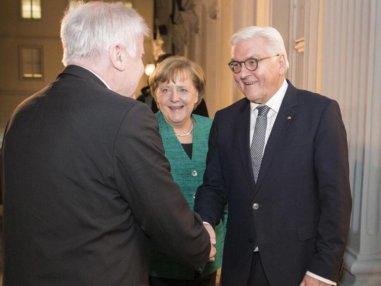 HANDOUT - Bundespräsident Frank-Walter Steinmeier (r) begrüßt am 30.11.2017 den CSU-Vorsitzenden Horst Seehofer (l) und die CDU-Vorsitzende Bundeskanzlerin Angela Merkel zu einem Gespräch in Schloss Bellevue in Berlin. Steinmeier beendete mit diesem Treffen eine Serie von Gesprächen, die er unmittelbar nach dem Scheitern der Sondierungen für eine Jamaika-Koalition aus Union, FDP und Grünen begonnen hatte, um Neuwahlen zu vermeiden. (ACHTUNG: Verwendung nur zu redaktionellen Zwecken im Rahmen der aktuellen Berichterstattung bei vollständiger Quellenangabe "Guido Bergmann/Bundesregierung/dpa" - Kein Verkauf) Foto: Guido Bergmann/Bundesregierung/dpa | Verwendung weltweit