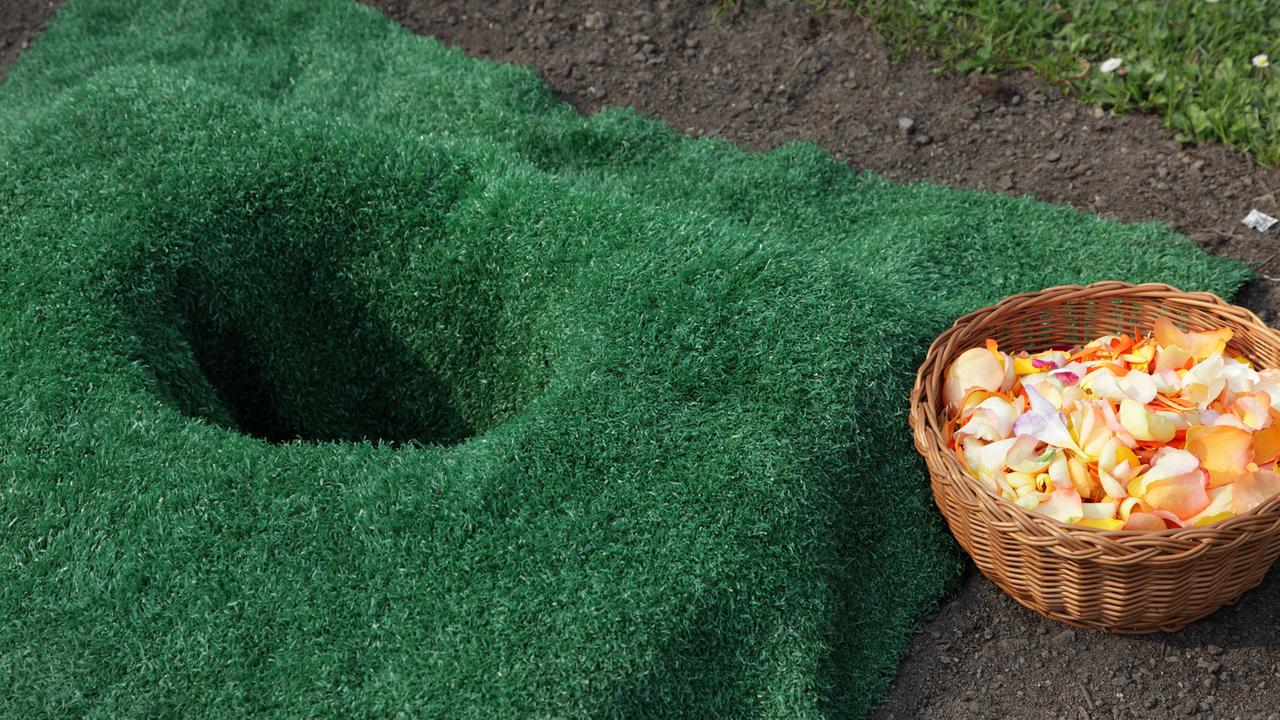 Vorbereitetes Urnenbegräbnis auf einem Friedhof Vorbereitetes Urnenbegräbnis auf einem Friedhof