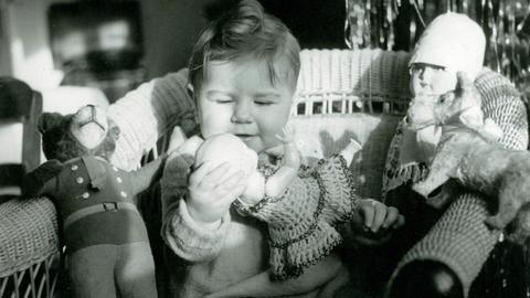 Ein kleines Mädchen spielt 1942 mit ihren Puppen und einem Teddy.