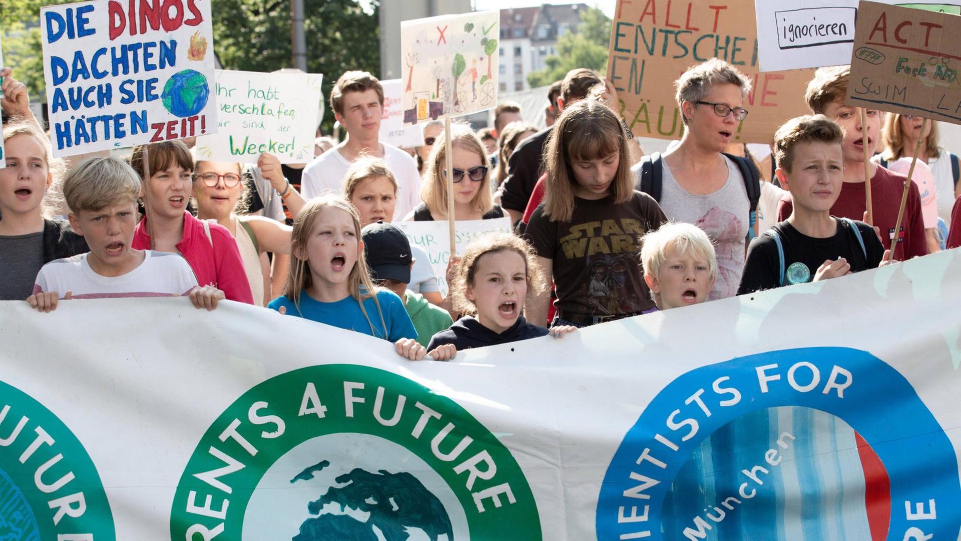 Menchen tragen auf einer Demo ein großes Transparent. Darauf steht "Parents 4 future" und "Scientists 4 future". Menchen tragen auf einer Demo ein großes Transparent. Darauf steht "Parents 4 future" und "Scientists 4 future".