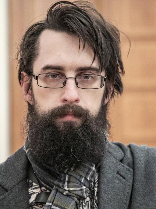 Der Schriftsteller Clemens J. Setz blickt in Richtung des Betrachters. Er trägt Brille und einen Vollbart.
