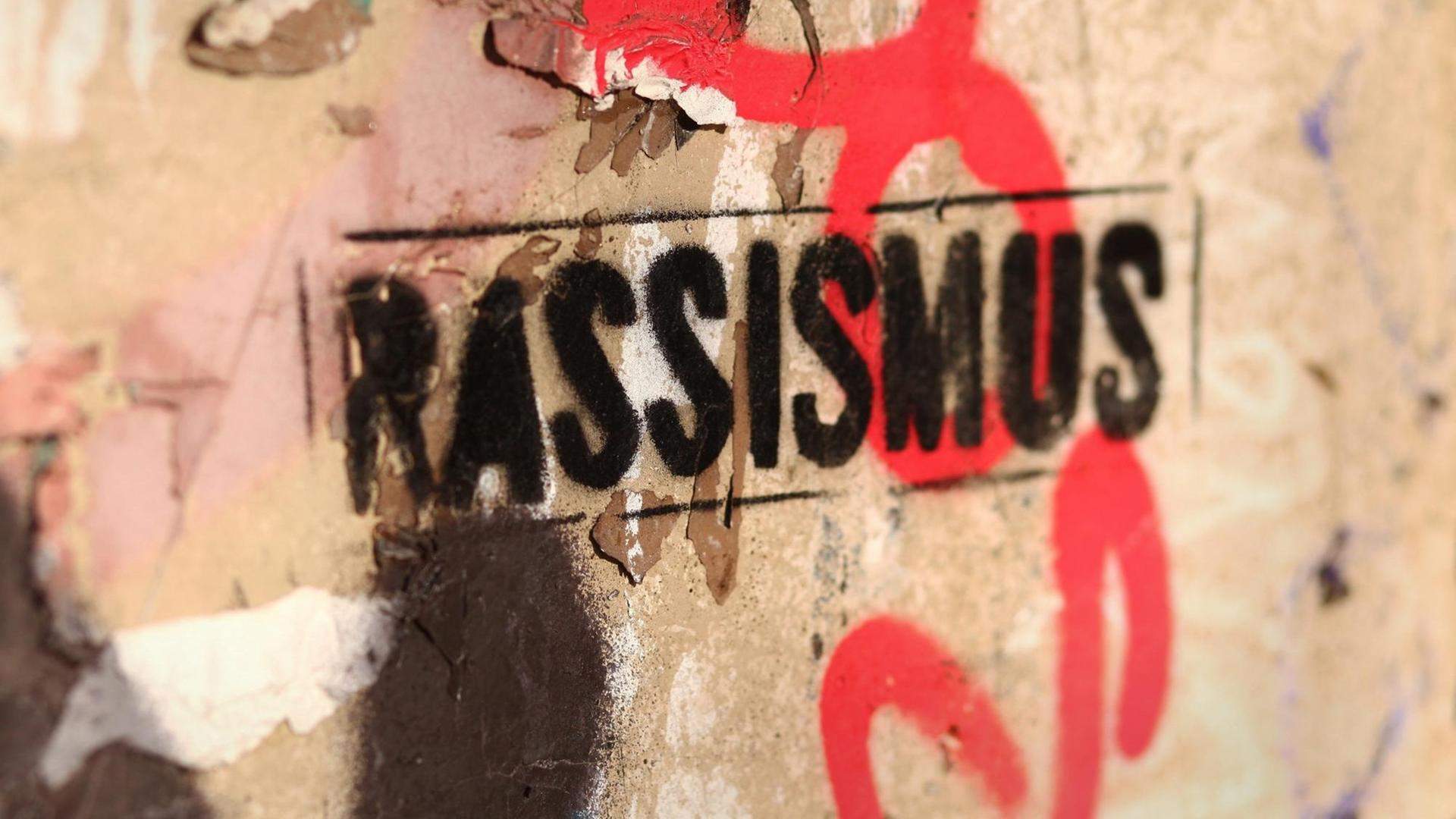 An eine beschmierte Wand ist das Wort "Rassismus" gesprüht worden. An eine beschmierte Wand ist das Wort "Rassismus" gesprüht worden.
