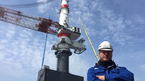 Projektleiter Keno Dirks vor dem neuen Super-Kran im Rostocker Hafen.