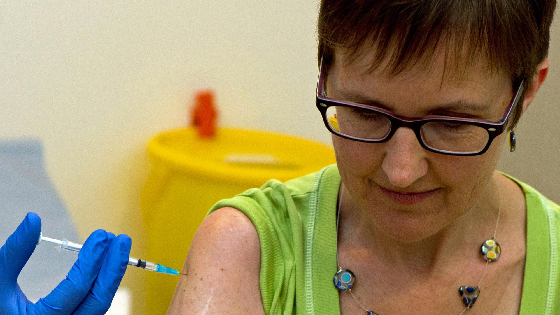 Eine Probandin bekommt einen möglichen Ebola-Impfstoff injiziert