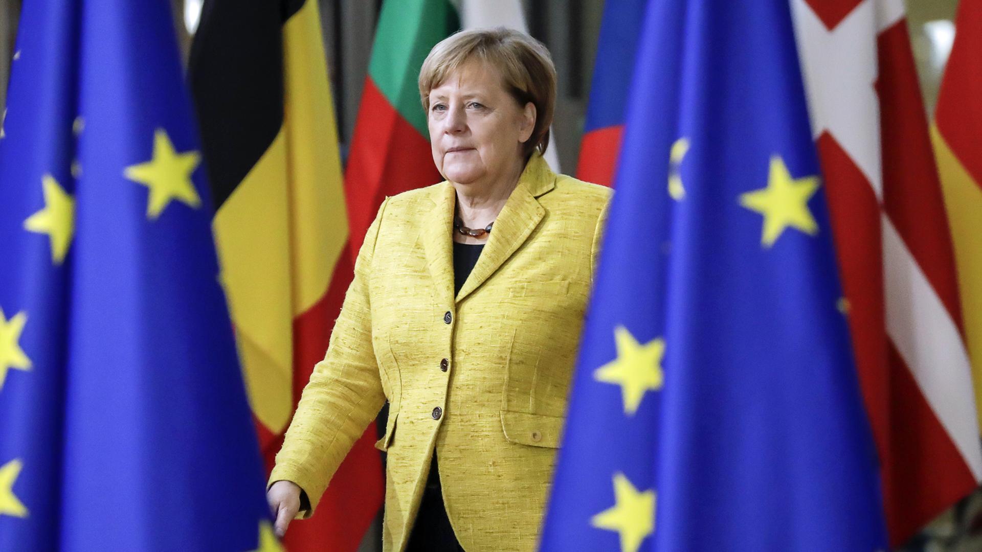 Angela Merkel bei ihrer Ankunft beim EU Summit im Dezember 2017 in Brüssel zwischen EU-Fahnen und Flaggen verschiedener EU-Länder Angela Merkel bei ihrer Ankunft beim EU Summit im Dezember 2017 in Brüssel zwischen EU-Fahnen und Flaggen verschiedener EU-Länder