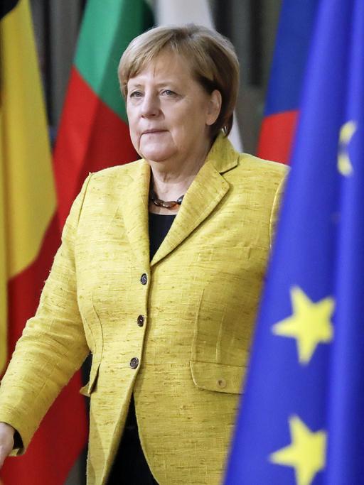 Angela Merkel bei ihrer Ankunft beim EU Summit im Dezember 2017 in Brüssel zwischen EU-Fahnen und Flaggen verschiedener EU-Länder