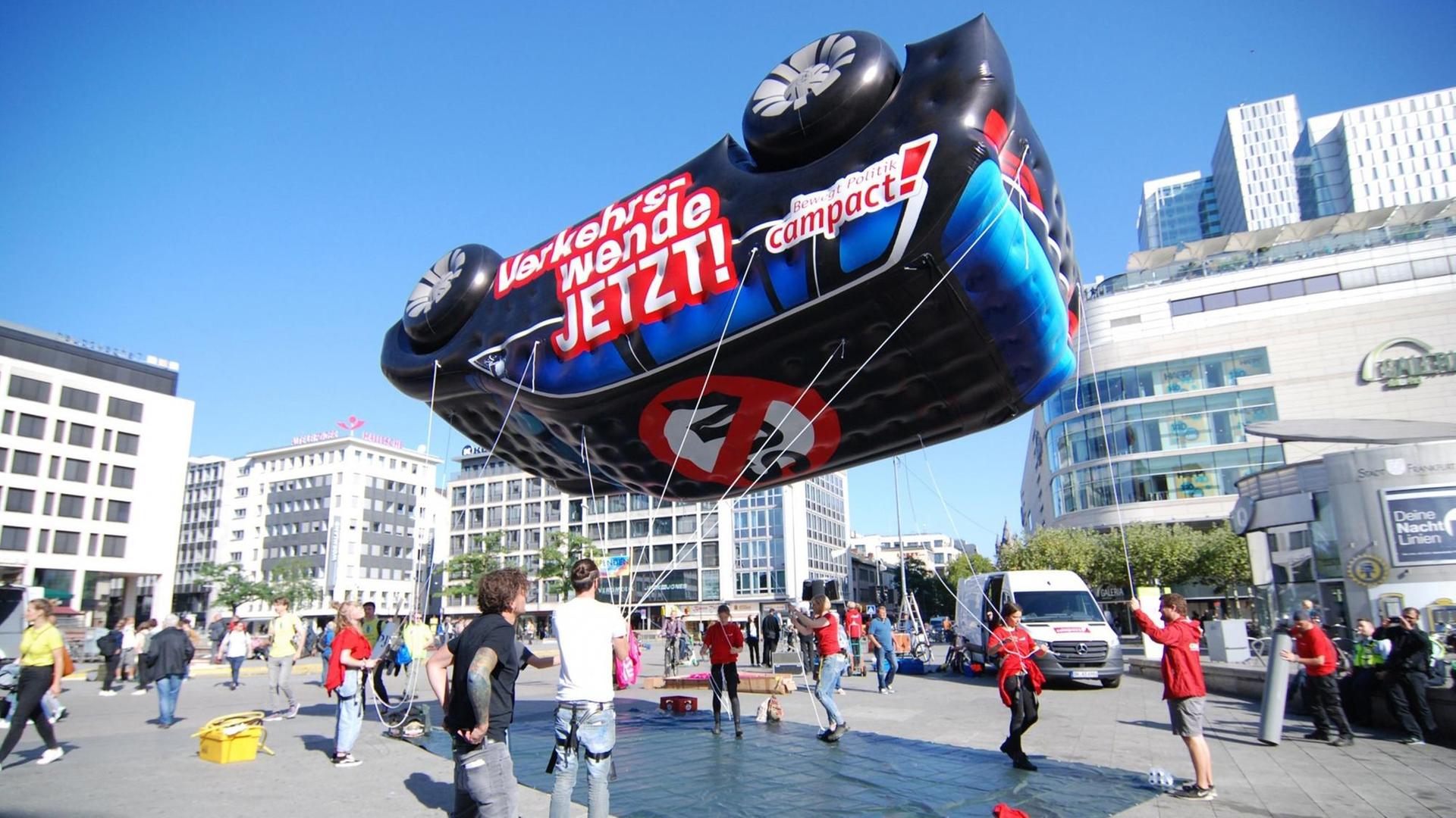 Campact-Aktivisten lassen ein mit Gas gefülltes SUV-Model abheben (2019). Campact-Aktivisten lassen ein mit Gas gefülltes SUV-Model abheben (2019).