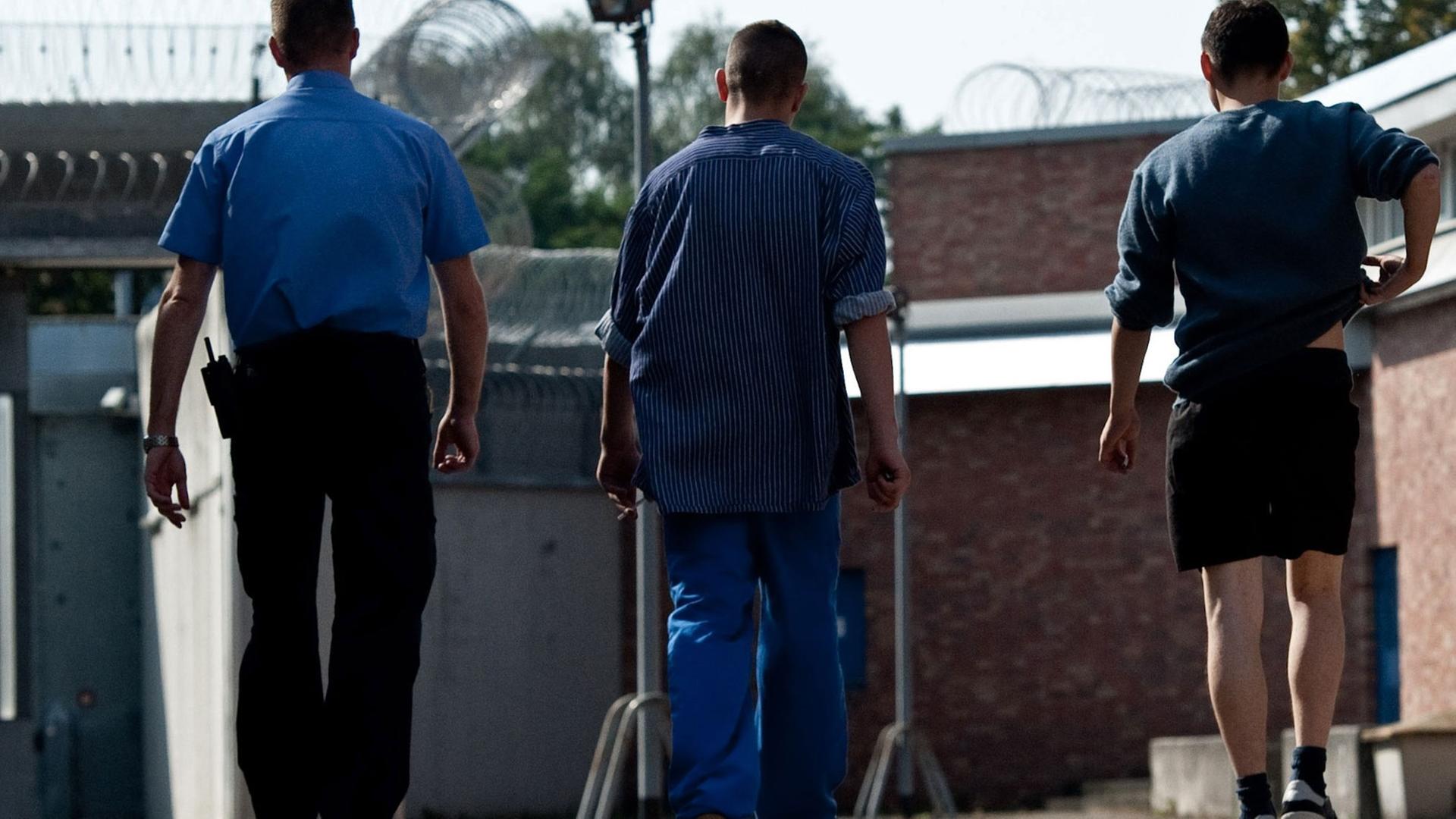 Zwei Gefangene gehen am 18.09.2012 in Betreuung eines Justizangestellten über das Gelände der Untersuchungs- und Jugendhaftanstalt Berlin-Tegel. Zwei Gefangene gehen am 18.09.2012 in Betreuung eines Justizangestellten über das Gelände der Untersuchungs- und Jugendhaftanstalt Berlin-Tegel.
