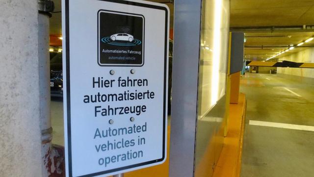 Warnschild am Eingang zum Parkhaus des Daimler-Museums mit der Aufschrift "Hier fahren automatisierte Fahrzeuge"