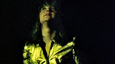 Suzi Q auf der Bühne in einem goldenen Anzug. Suzi Q auf der Bühne in einem goldenen Anzug.