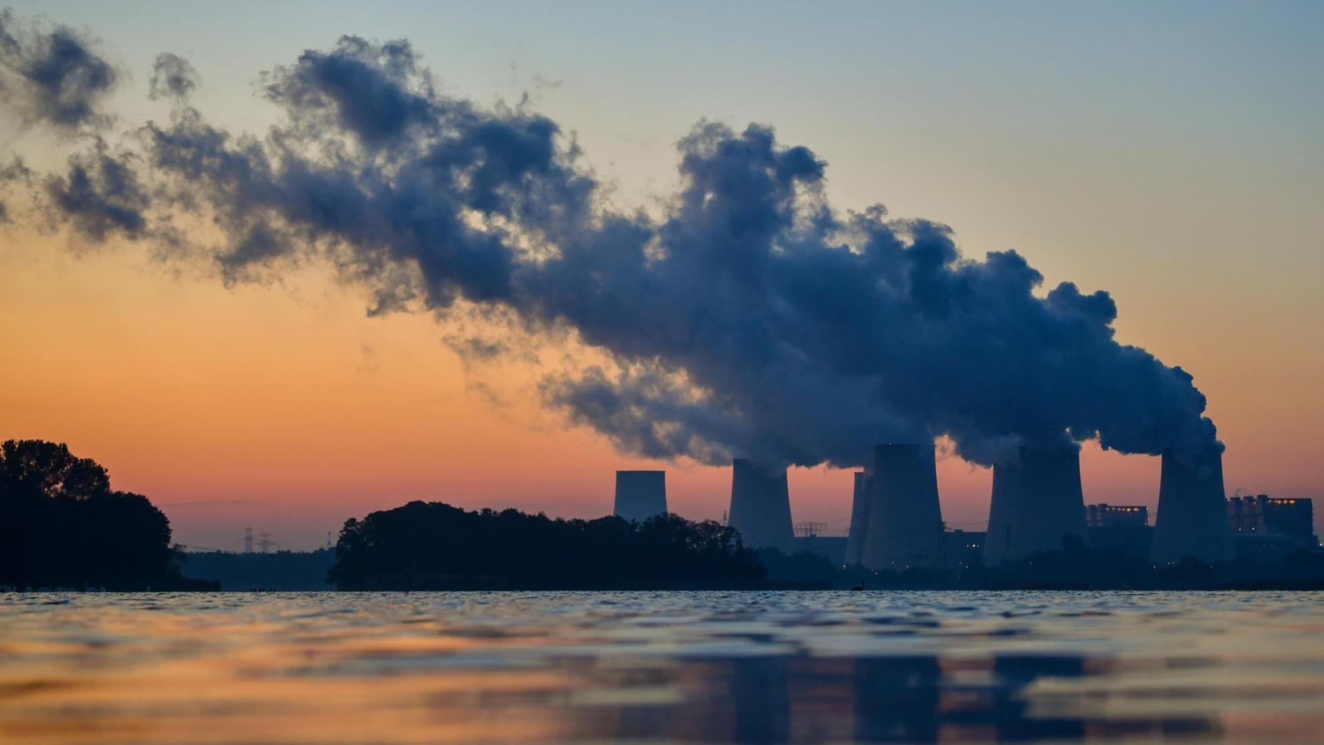 Wasserdampfschwaden steigen vor Sonnenaufgang in den farbigen Morgenhimmel aus den Kühltürmen des Braunkohlekraftwerkes Jänschwalde der LEAG (Lausitz Energie Bergbau AG) hinter einem Karpfenteich in Peitz (Brandenburg). Wasserdampfschwaden steigen vor Sonnenaufgang in den farbigen Morgenhimmel aus den Kühltürmen des Braunkohlekraftwerkes Jänschwalde der LEAG (Lausitz Energie Bergbau AG) hinter einem Karpfenteich in Peitz (Brandenburg).
