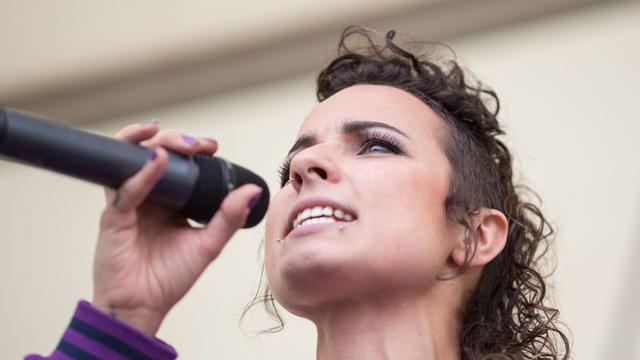 Die feministische Sängerin Sookee steht am 01.09.2013 am Pariser Platz in Berlin mit einem Mikrofon in der Hand auf der Bühne.