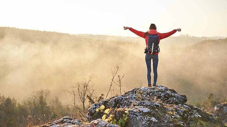 Woman on a hiking trip in the mountains standing on rock enjoying the view model released Symbolfoto PUBLICATIONxINxGERxSUIxAUTxHUNxONLY BSZF00970 Woman on a hiking trip in the mountains standing on rock enjoying the view model released Symbolfoto PUBLICATIONxINxGERxSUIxAUTxHUNxONLY BSZF00970