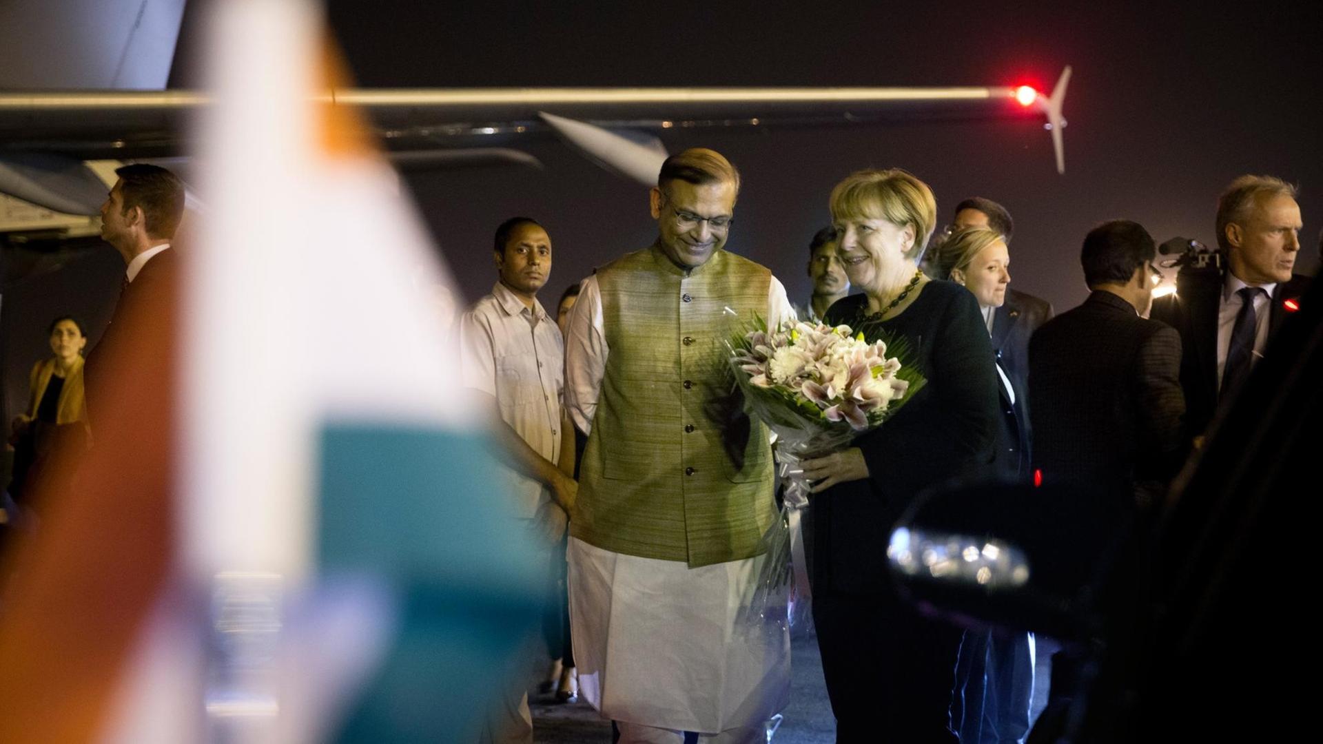 Bundeskanzlerin Angela Merkel (CDU) wird am 04.10.2015 auf dem militärischen Teil des Flughafens Indira-Gandhi-International in Neu Delhi vom indischen Staatsminister für Finanzen Jayant Sinha begrüßt. Hier nimmt die Kanzlerin an den dritten deutsch-indischen Regierungskonsultationen teil. Bei dem Treffen mit der national-hinduistischen Regierung von Premierminister Modi geht es schwerpunktmäßig um Klima-, Wirtschafts- und Bildungspolitik.