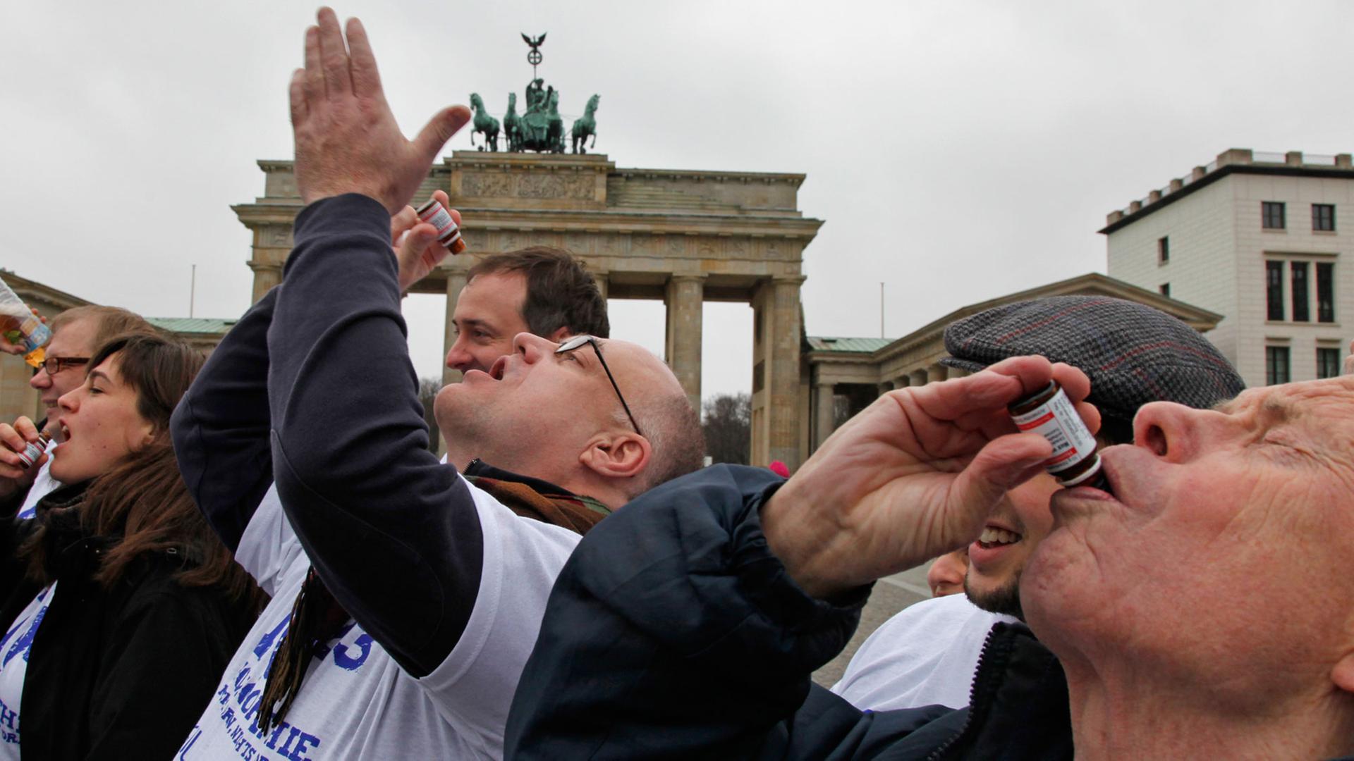 Mitglieder der "Berliner Skeptiker" schlucken im Februar 2011 in Berlin vor dem Brandenburger Tor eine "Überdosis" eines homöopathischen Mittels