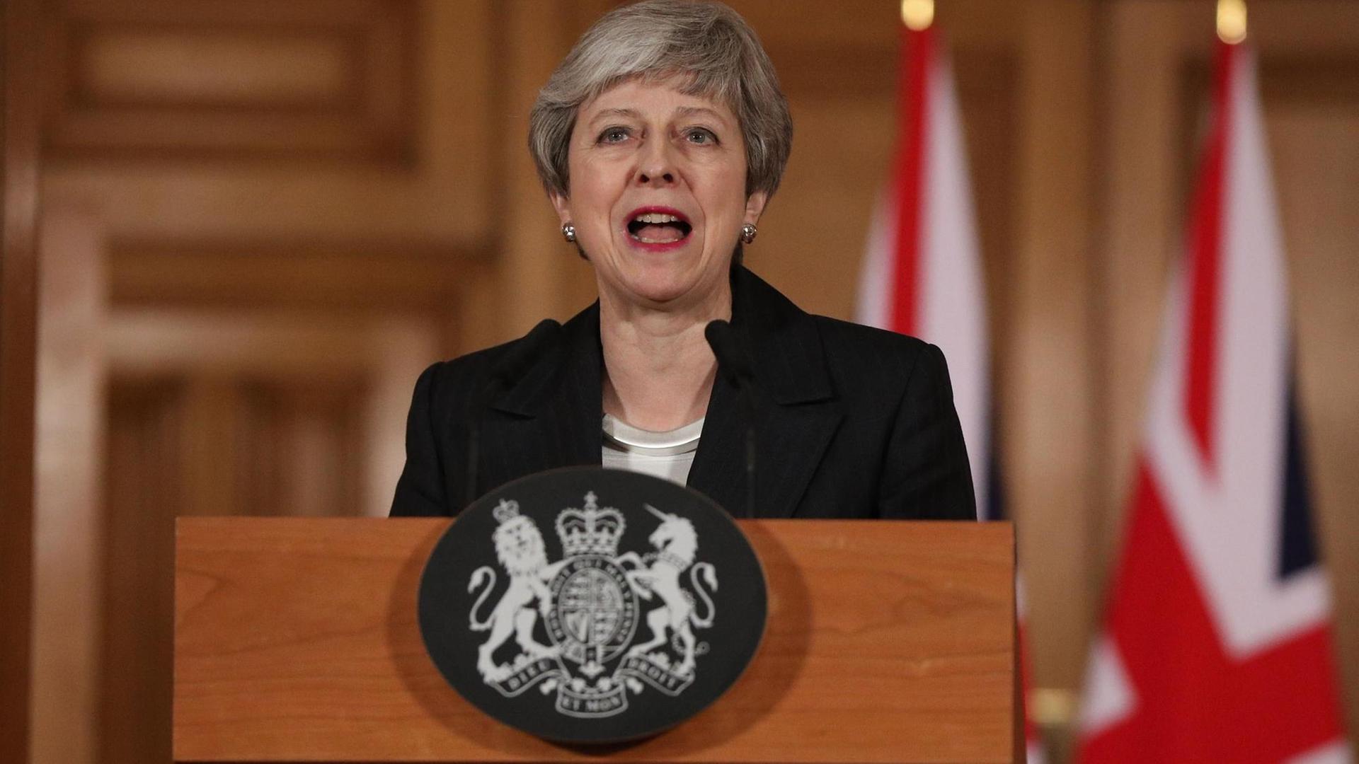 Das Bild zeigt Theresa May an einem Rednerpult. Sie spricht in ein Mikrofon.