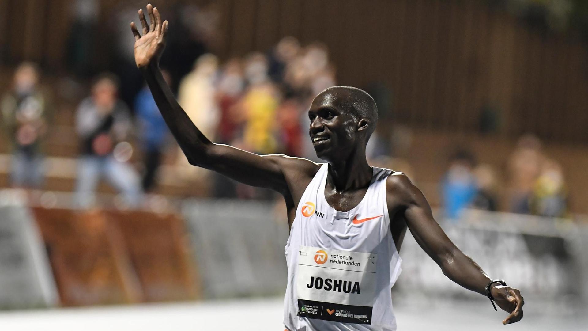 Joshua Cheptegei winkt im Stadion dem Publikum zu. Joshua Cheptegei winkt im Stadion dem Publikum zu.