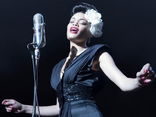 Eine elegante Jazz-Sängerin im schwarzen Kleid auf der Bühne