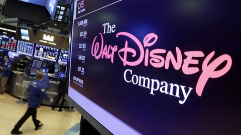 Das Logo des US-Unterhaltungsriesen Disney auf einem Bildschirm, im Hintergrund das Handelsparkett der New Yorker Börse