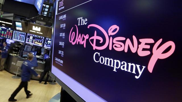 Das Logo des US-Unterhaltungsriesen Disney auf einem Bildschirm, im Hintergrund das Handelsparkett der New Yorker Börse