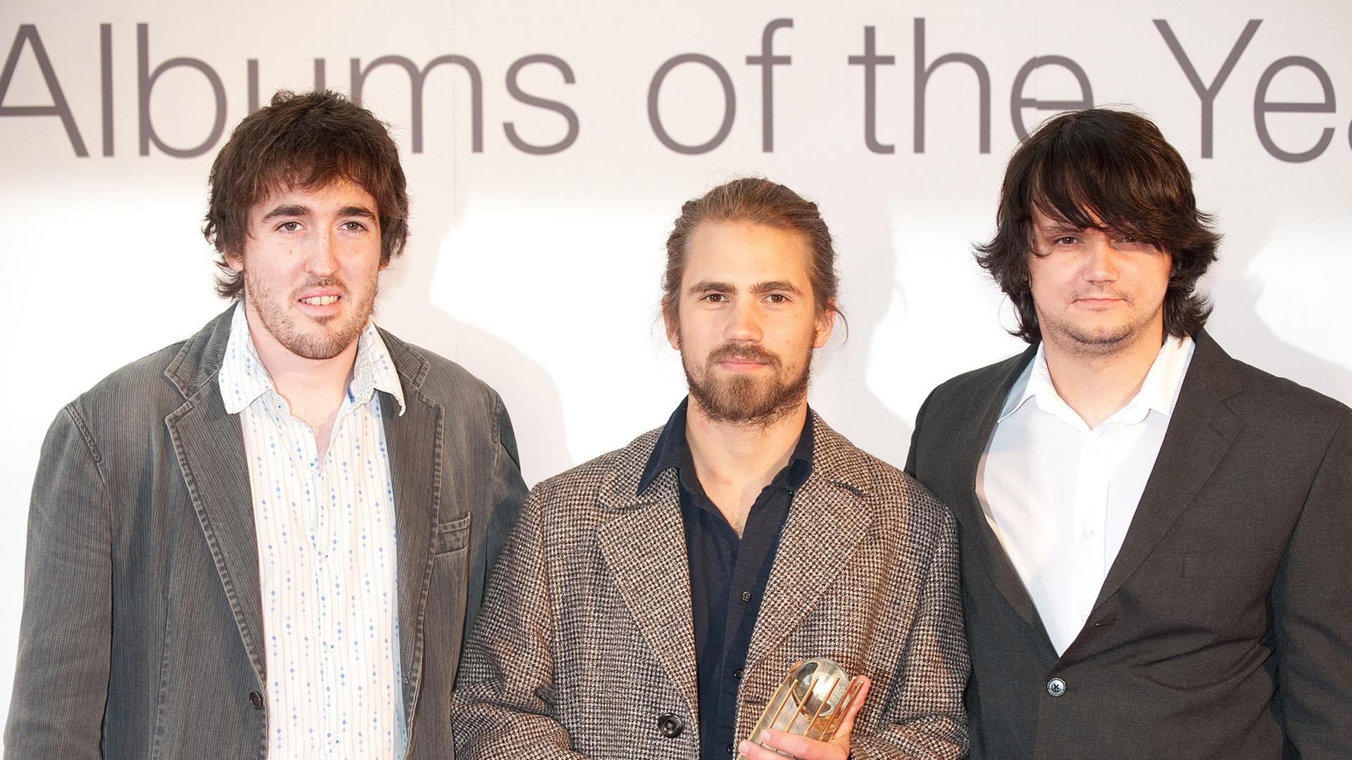Das Kit Downes Trio hält die Trophäe des  "Mercury Music Prize" in den Händen.