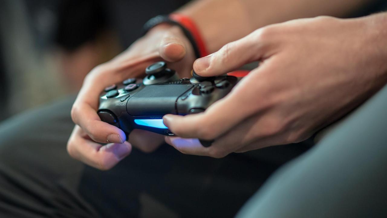 Das Finale 2017/2018 der Virtuellen Bundesliga, ein Spieler hält ein Playstation-Controller in der Hand. Das Finale 2017/2018 der Virtuellen Bundesliga, ein Spieler hält ein Playstation-Controller in der Hand.
