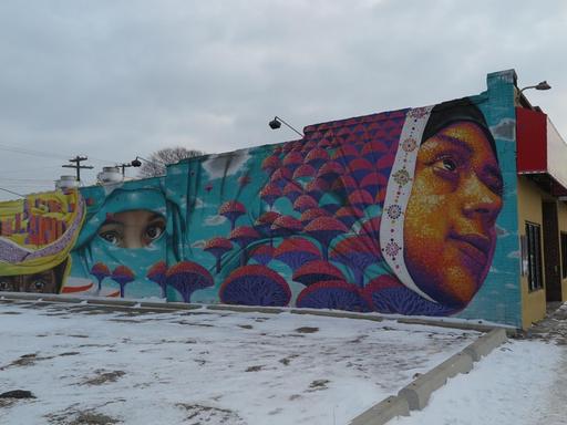 Ein Grafitti mit jeminitischen Frauen auf einer Häuserwand.