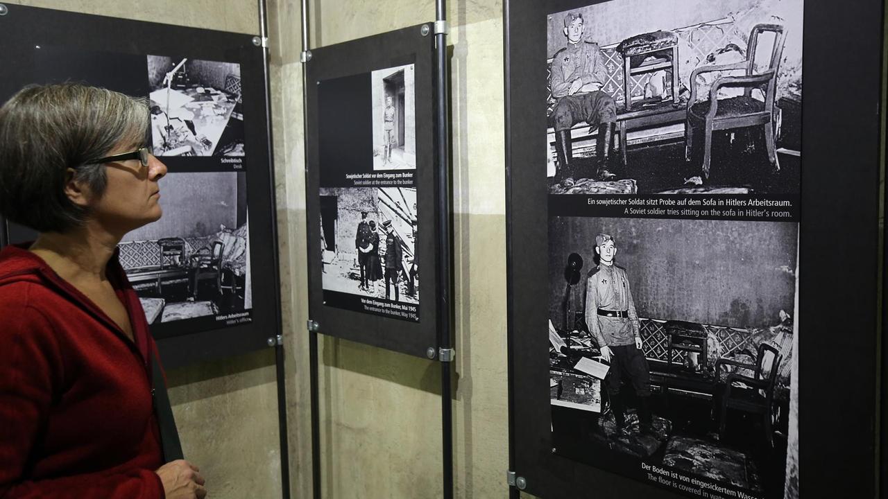 Eine Frau betrachten am 27.10.2016 in Berlin, während einer Ausstellungseröffnung der Dokumentation Führerbunker des Vereins Historiale, Fotodokumente des Bunkers, die von russischen oder amerikanischen Soldaten gemacht wurden.