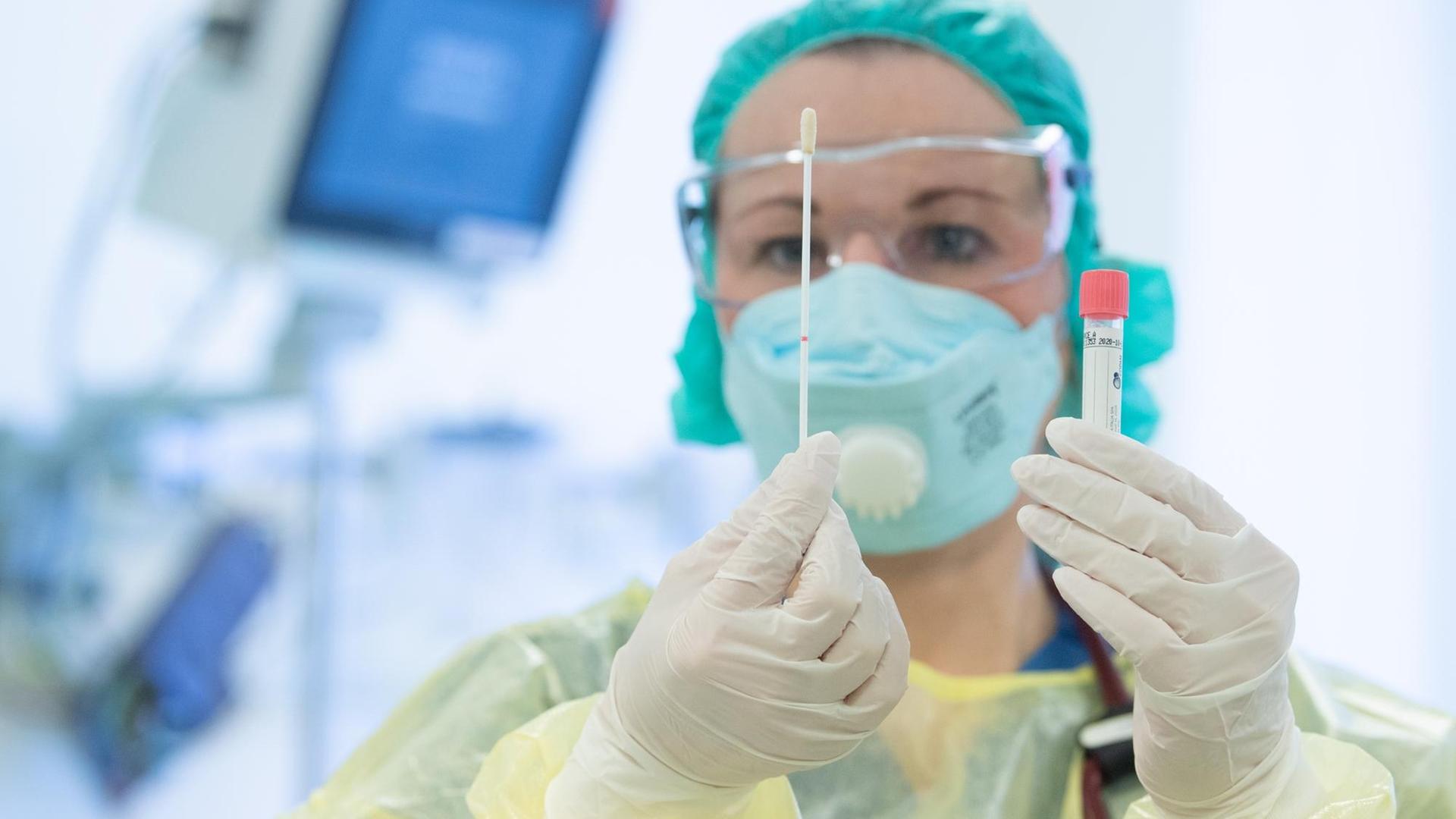 Eine Krankenschwester legt auf der Isolierstation für Coronavirus-Behandlungen ihre Schutzkleidung an bevor sie ein Patientenzimmer betritt. Eine Krankenschwester legt auf der Isolierstation für Coronavirus-Behandlungen ihre Schutzkleidung an bevor sie ein Patientenzimmer betritt.