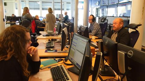 NorwegischeJournalisten sitzen in einem Großraum-Büro vor ihren Computern