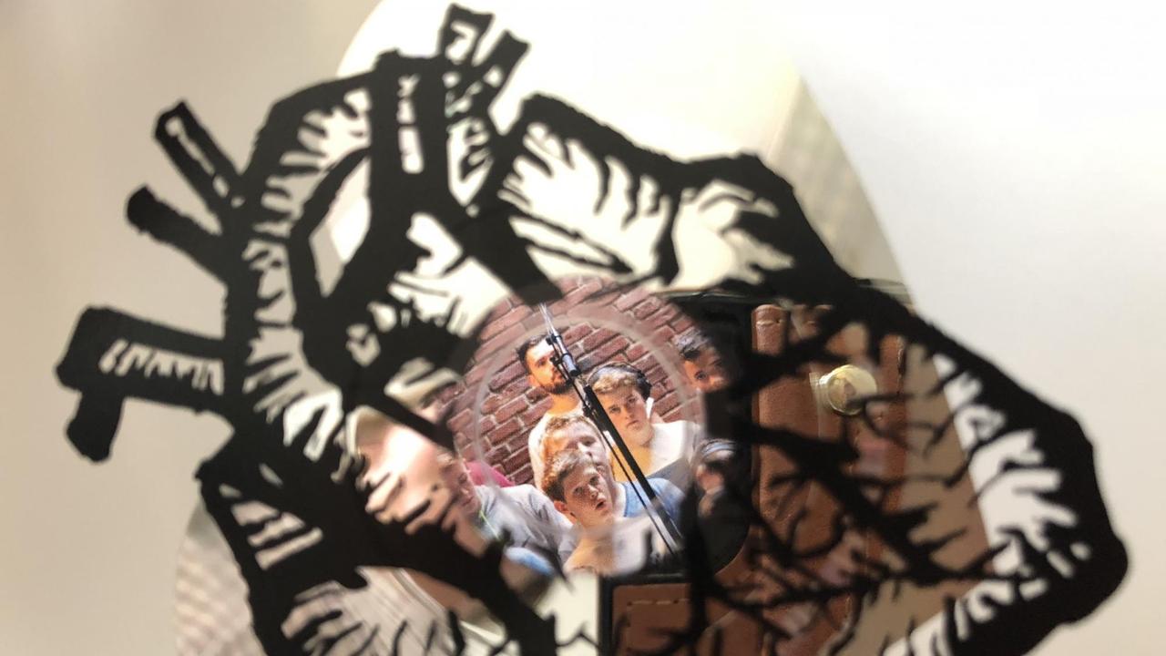 Blick durch das CD-Loch auf ein Foto mit den Kindern, die im Aufnahmestudio stehen Blick durch das CD-Loch auf ein Foto mit den Kindern, die im Aufnahmestudio stehen