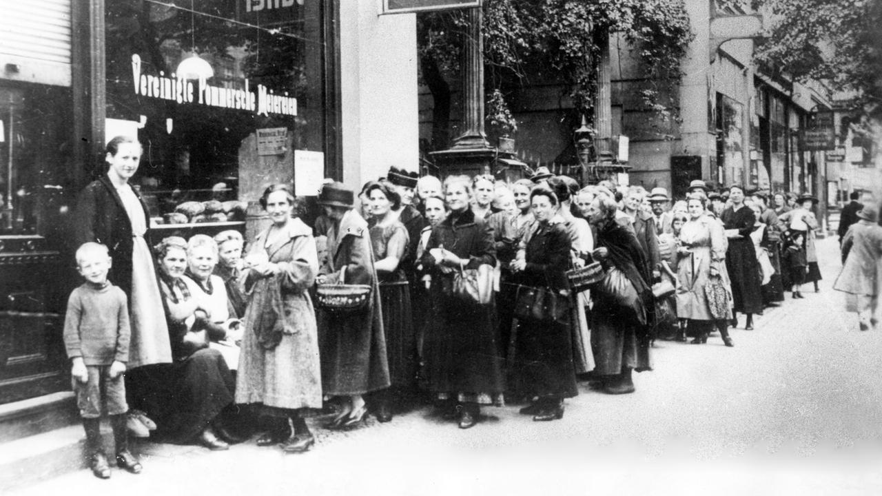 Hunger an der Heimatfront: Frauen und Kinder stehen 1917 in Berlin Schlange an einem Lebensmittelgeschäft. Im Januar 1915 war zunächst Brot rationiert worden, es folgten weitere Lebensmittel.