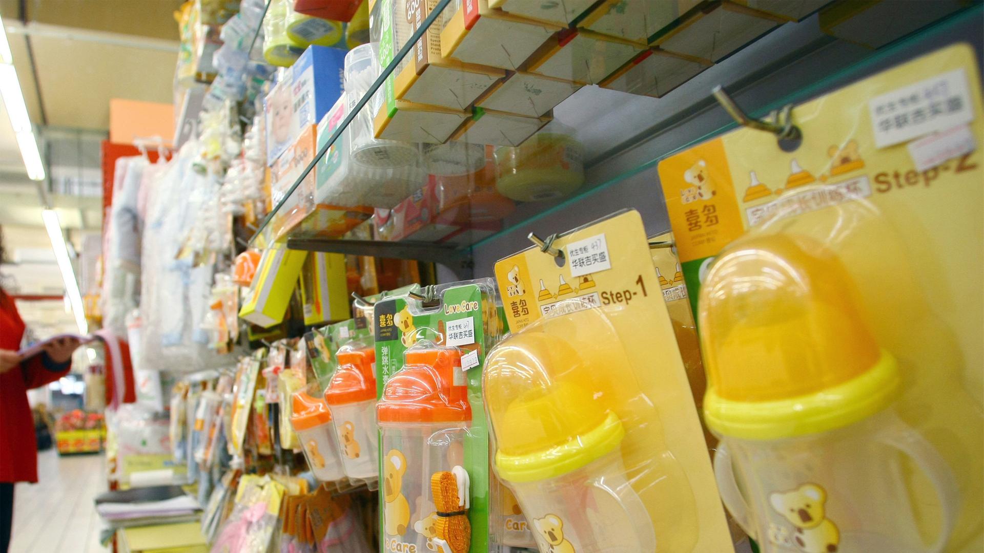 Babyflaschen hängen in einem Supermarktregal. 