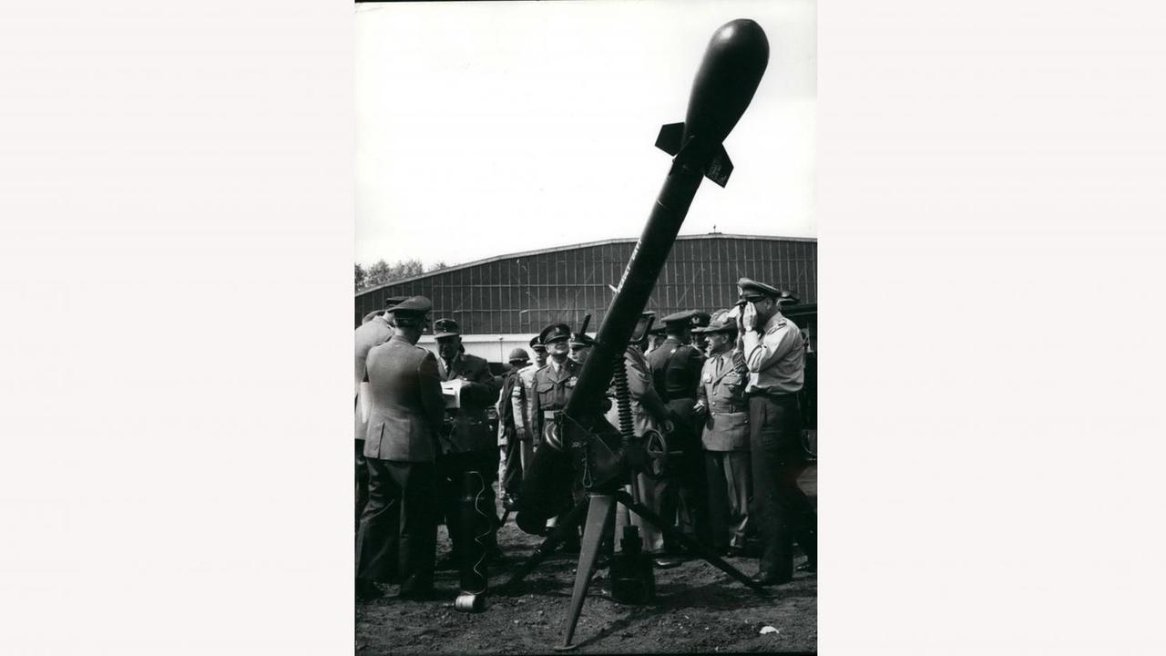 Demonstration der taktischen Atomwaffe "Davy Crocket" 1962 in der Nähe von Frankfurt. Die Mini-Rakete ist auf einer schräg ausgerichteten Lafette aufgebaut, Militärangehörige betrachten die taktische Atomwaffe.