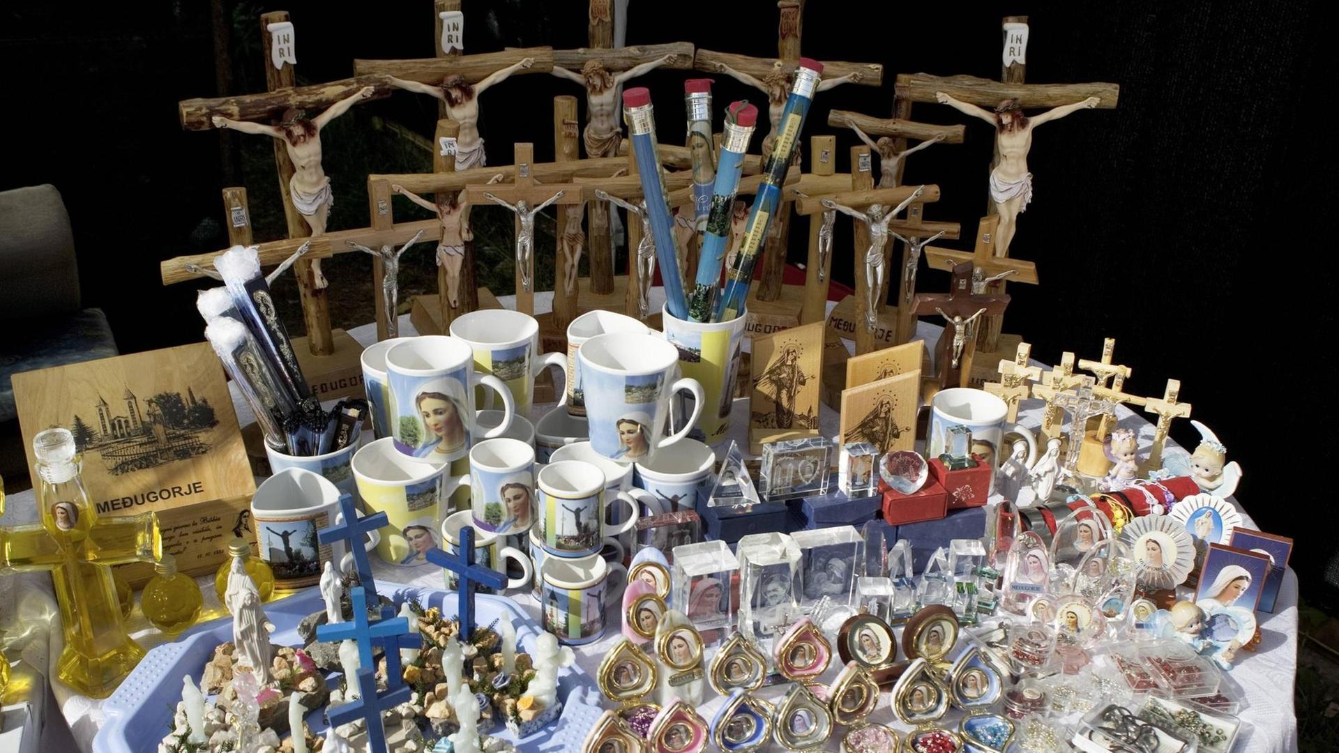 Religiöse Souvenirs - Tassen, Anstecker und Figuren mit Jesus am Kreuz - in Medjugorje