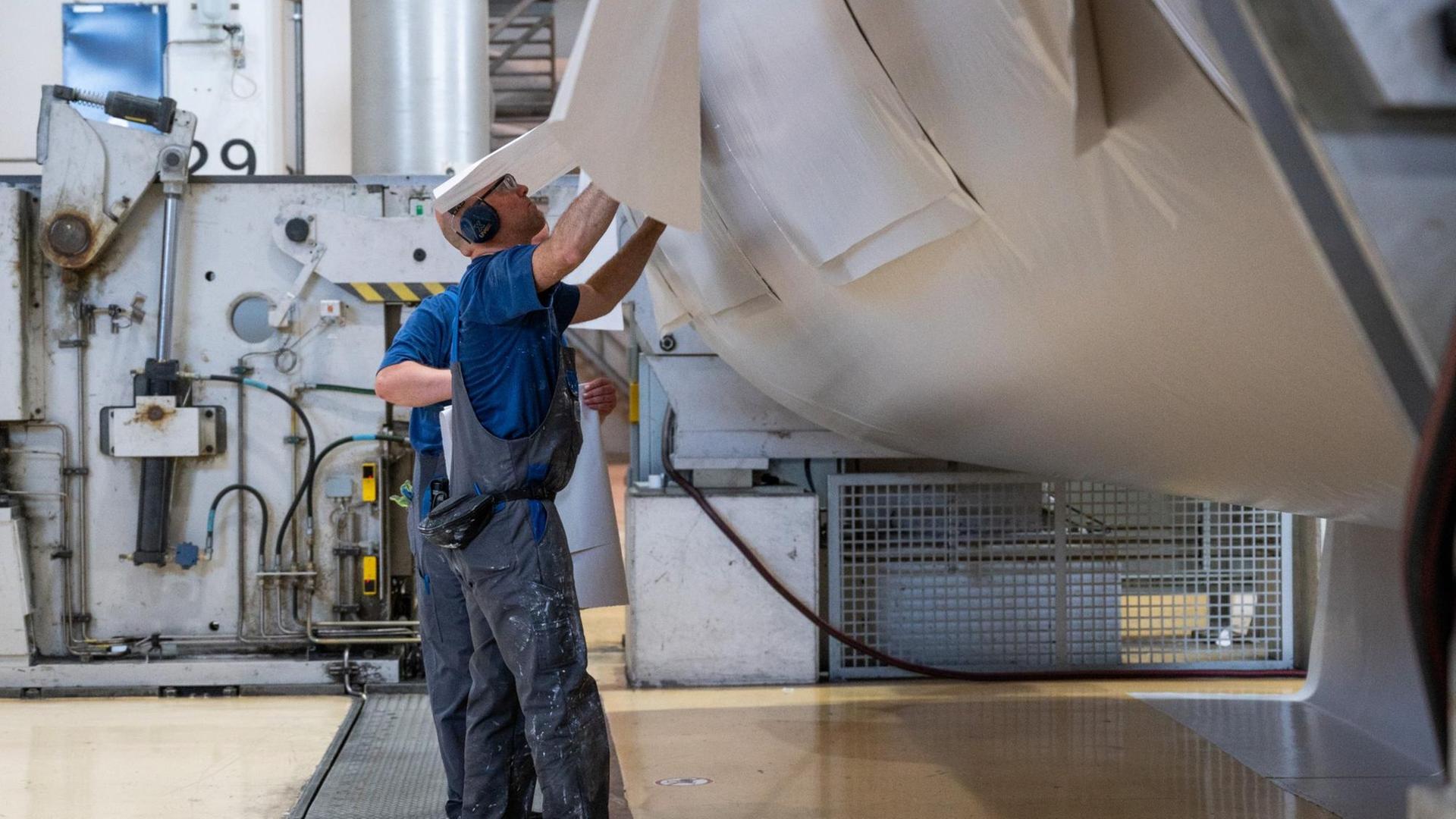 Zwei Arbeiter bearbeiten eine Papierrolle in der Papierfabrik des Herstellers Leipa in Schwedt/Oder. Zwei Arbeiter bearbeiten eine Papierrolle in der Papierfabrik des Herstellers Leipa in Schwedt/Oder.
