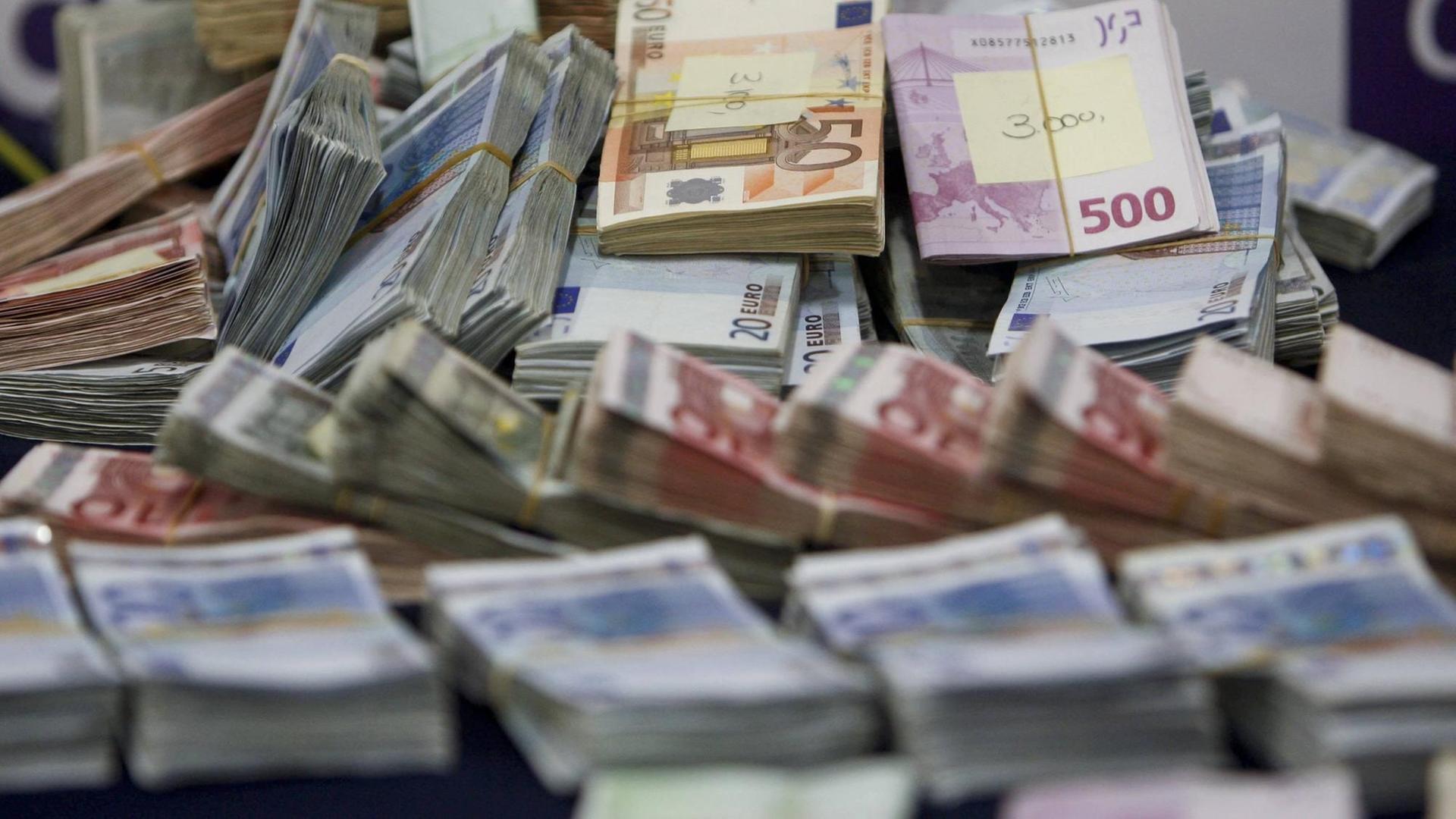 Beschlagnahmte Euroscheine liegen in Bündeln auf einem Tisch. Beschlagnahmte Euroscheine liegen in Bündeln auf einem Tisch.