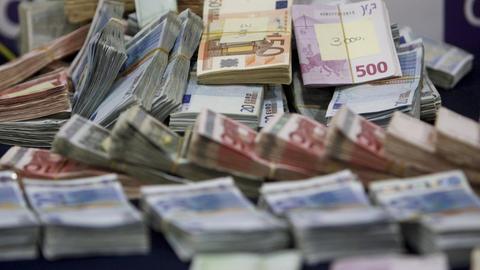 Beschlagnahmte Euroscheine liegen in Bündeln auf einem Tisch.