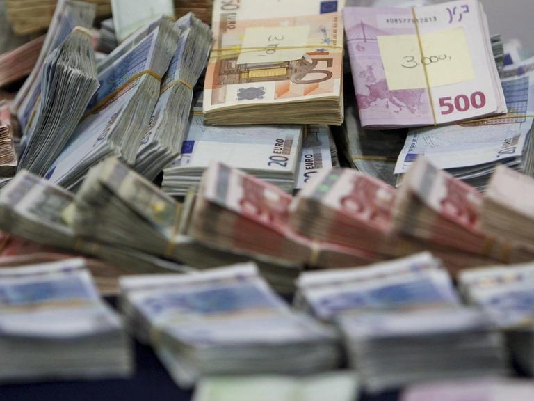 Beschlagnahmte Euroscheine liegen in Bündeln auf einem Tisch.
