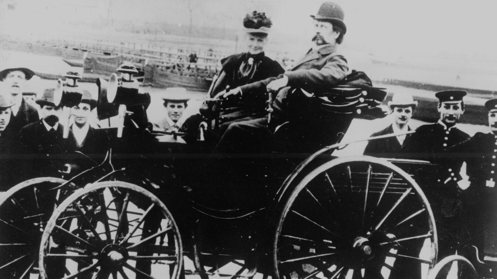 Historisches  Bild von Berta und Carl Benz in einem Automobil. 
