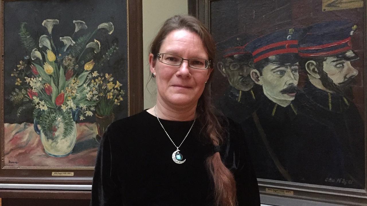 Salka Schallenberg steht vor den Gemälden "Blumenstück" und "Der Briefträger" ihres Großvaters Otto Nagel im Staatlichen Museum Schwerin. Salka Schallenberg steht vor den Gemälden "Blumenstück" und "Der Briefträger" ihres Großvaters Otto Nagel im Staatlichen Museum Schwerin.