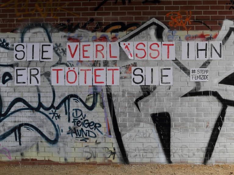 "SIE VERLÄSST IHN - ER TÖTET SIE - #Stopp Femizide" steht auf Zetteln an einer Mauer mit Graffiti in Potsdam am 14. April 2021.