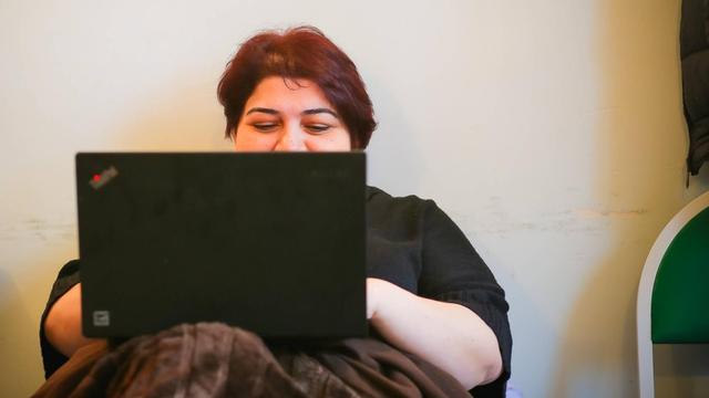 Khadija Ismayilova liegt in einem Bett und tipp in ein Notebook